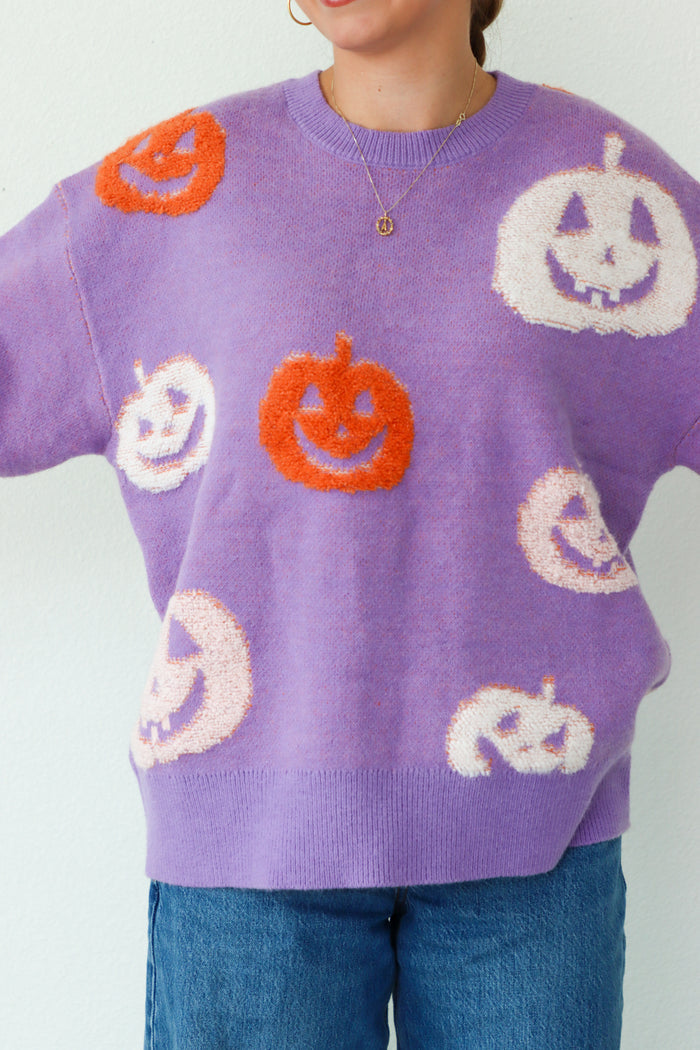 girl wearing purple sweater with orange and white jack o lanterns